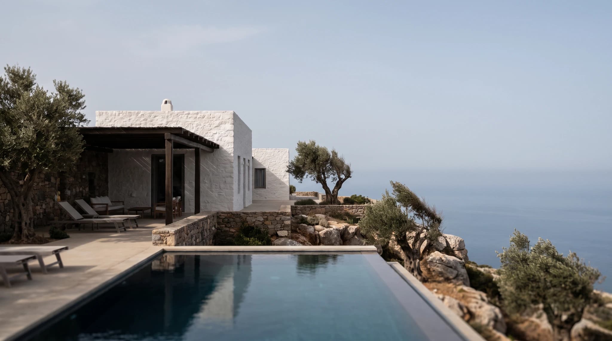 Photorealistic concrete house set into a rocky coastal landscape.